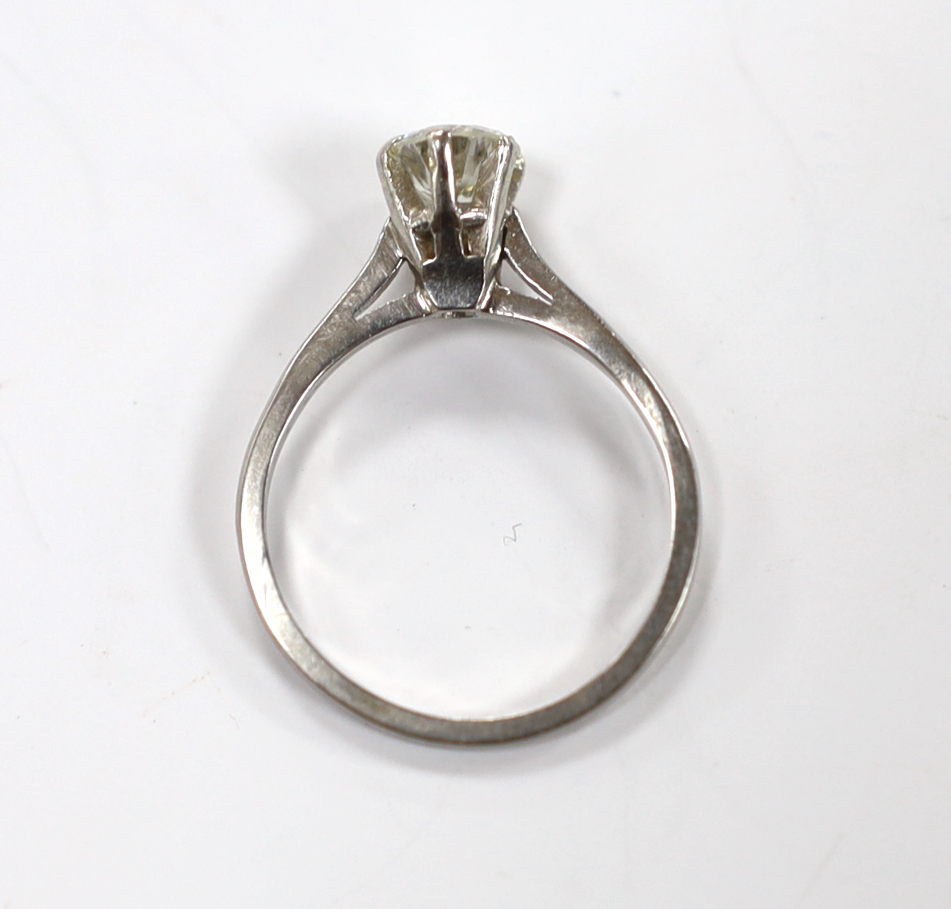 A white metal (stamped plat) and solitaire diamond set ring, size L/M, gross weight 3.5 grams, the stone with a diameter of 6mm.